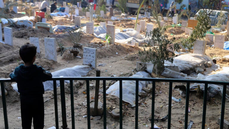 A Palestinian child looks at the graves of people killed in the Israeli bombardment of the Gaza Strip.