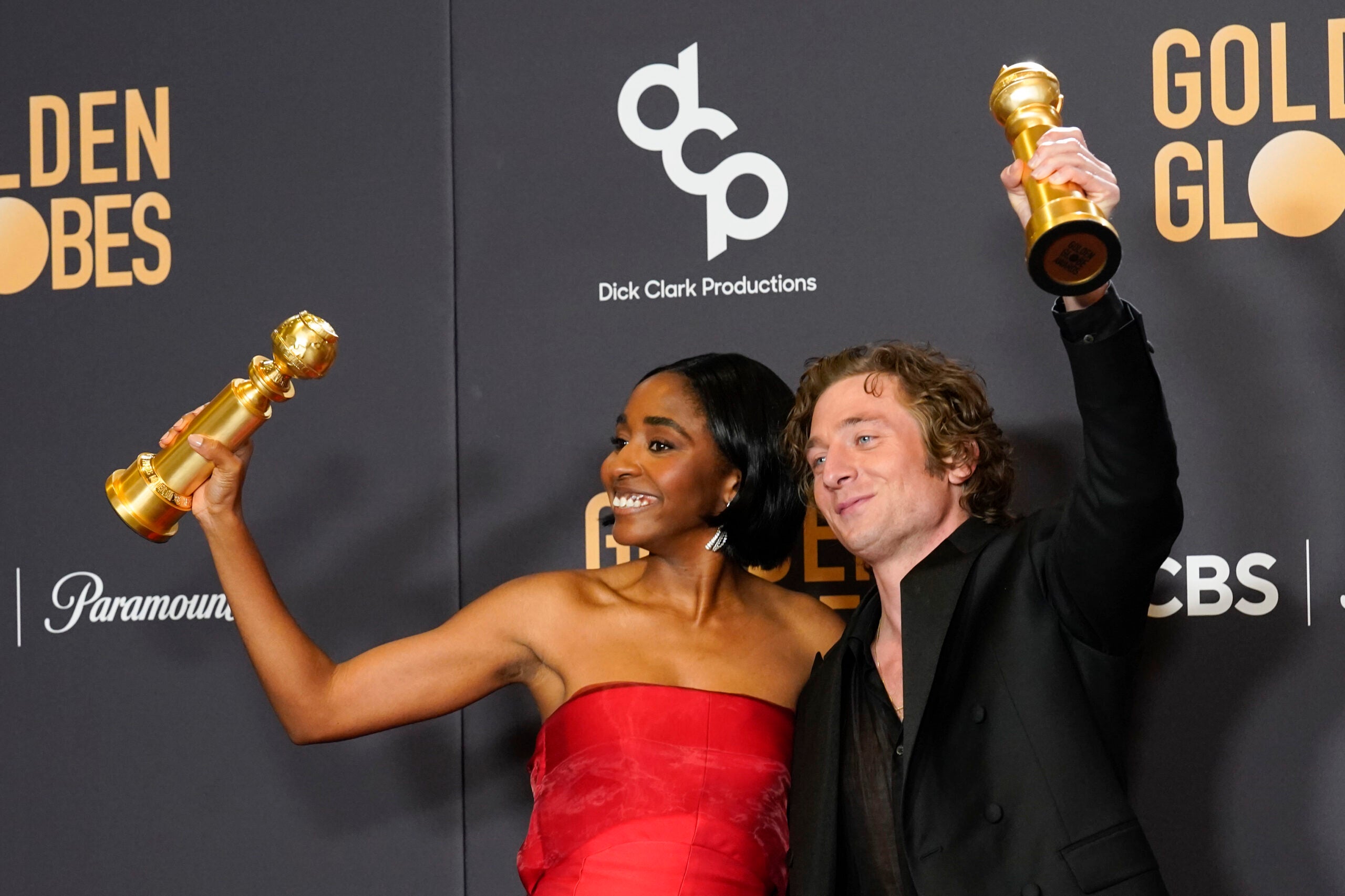 Ayo Edebiri and Jeremy Allen White hold up their Golden Globes awards. 