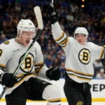 Boston Bruins center Charlie Coyle (13) celebrates his goal against the Tampa Bay Lightning with center Trent Frederic (11) during the third period of an NHL hockey game Monday, Nov. 20, 2023, in Tampa, Fla.