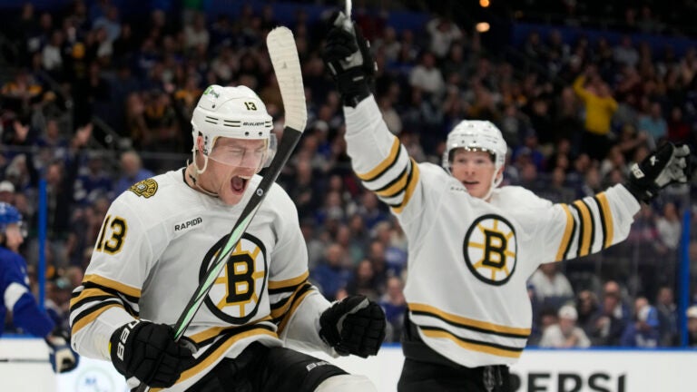 Boston Bruins center Charlie Coyle (13) celebrates his goal against the Tampa Bay Lightning with center Trent Frederic (11) during the third period of an NHL hockey game Monday, Nov. 20, 2023, in Tampa, Fla.