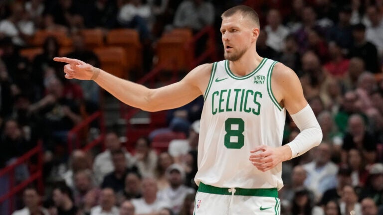 Boston Celtics center Kristaps Porzingis (8) gestures after scoring a three-point basket during the first half of an NBA basketball game against the Miami Heat, Thursday, Jan. 25, 2024, in Miami.
