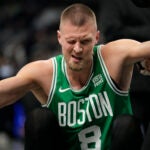 Boston Celtics center Kristaps Porzingis (8) gets helped up after injuring his eye while playing the Indiana Pacers during the first half of an NBA basketball game in Indianapolis, Saturday, Jan. 6, 2024.
