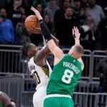 Boston Celtics center Kristaps Porzingis (8) fouls Indiana Pacers guard Bennedict Mathurin (00) in the final second of the second half of an NBA basketball game in Indianapolis, Monday, Jan. 8, 2024. The Pacers defeated the Celtics 133-131.