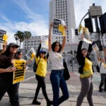 Members of the Los Angeles Times Guild carry signs and chant slogans in front of Los Angeles City Hall.