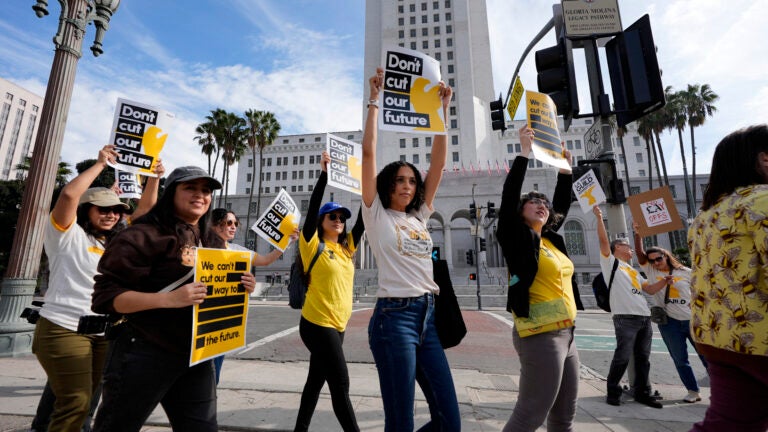 Members of the Los Angeles Times Guild carry signs and chant slogans in front of Los Angeles City Hall.