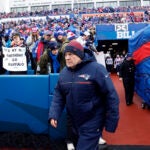 New England Patriots head coach Bill Belichick walks onto the field to face the Buffalo Bills at Highmark Stadium.