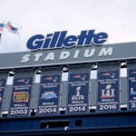 Championship banners hang at Gillette Stadium before an NFL football game in Foxborough, Mass on Sept. 22, 2019. Two Rhode Island men, John Vieira and Justin Mitchell, have been charged with assault and battery and disorderly conduct by police in connection with the death of a fan, Dale Mooney, at a New England Patriots game in September.