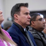 Texas State Sen. Roland Gutierrez, D-Texas, center, sits with family members of shooting victims as they listen to Attorney General Merrick B.