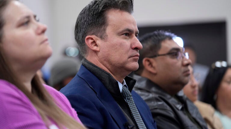Texas State Sen. Roland Gutierrez, D-Texas, center, sits with family members of shooting victims as they listen to Attorney General Merrick B.