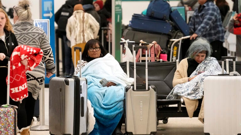 Ana Rosario of Houston tries to keep warm as she waits on her flight.