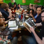 Nick Hansen of Natick, left, Cristina Rivera of Chelsea, second from right, and Jesse Bromley, of Dorchester were among during a comic book reading group meeting at the Friendly Toast in Cambridge.
