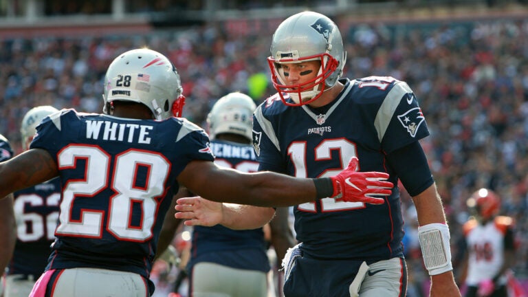 Patriots quarterback Tom Brady (right) celebrates with running back James White (left) after they hooked up for a third quarter touchdown pass, their second of the game. Gillette Stadium Cincinnati Bengals at New England Patriots - 3rd quarter action.