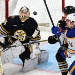 Boston Bruins goaltender Linus Ullmark (35) keeps his eyes on the puck after a close shot, as Sabres Dylan Cozens battles Bruins Brandon Carlo for position in front of the net in the 1st period.