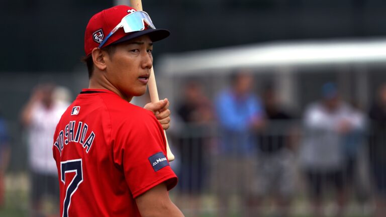 Masataka Yoshida looks back over his shoulder, with a bat