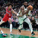 Celtics guard Jaylen Brown drives to the basket past Philadelphia 76ers guard Kelly Oubre Jr. during the first half.