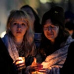 Abbie Lewis, left, and Jackie Batista-Martinez attend a candlelight vigil for victims.