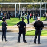 Houston Police officers watch over displaced churchgoers outside Lakewood Church.