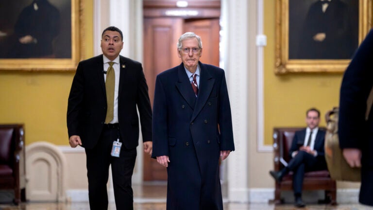 Senate Minority Leader Mitch McConnell, R-Ky., right, arrives at the Capitol in Washington.