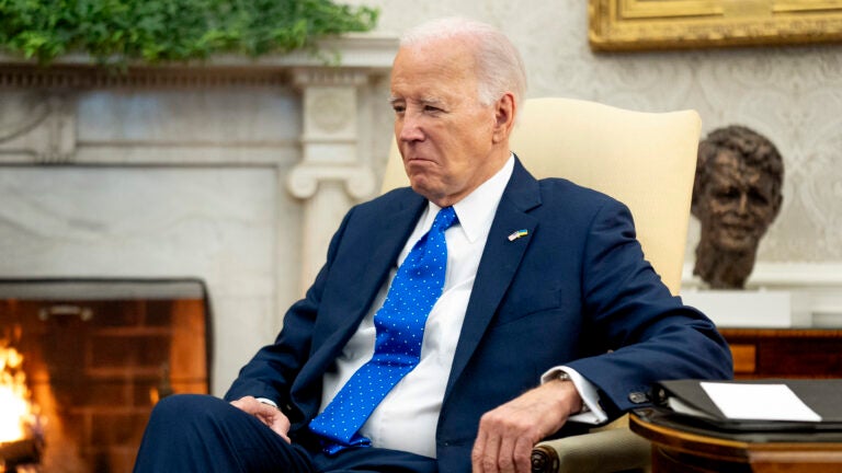 President Joe Biden sits in the Oval Office.
