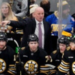 Boston Bruins coach Jim Montgomery calls to officials during the first period of the team's NHL hockey game against the Carolina Hurricanes, Wednesday, Jan. 24, 2024, in Boston.