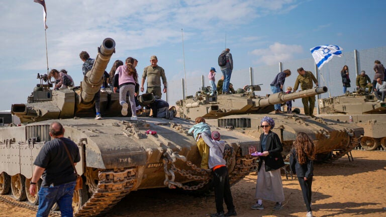 Israelis stand on tanks.