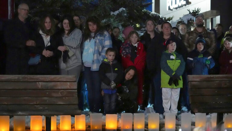 People attend a candlelight vigil after two police officers and a first responder were shot and killed Sunday, Feb. 18, 2024, in Burnsville, Minn.
