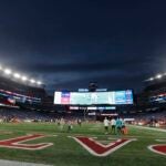 FILE — Lights illuminate Gillette Stadium before an NFL football game between the New England Patriots and the Miami Dolphins, Sunday, Sept. 17, 2023, in Foxborough, Mass. One of two Rhode Island men charged with assault and battery and disorderly conduct in connection with the death of a fan at a New England Patriots game pleaded not guilty Friday, Jan. 19, 2024.