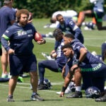 Seattle Seahawks run game coordinator Andy Dickerson, left, talks with players during NFL football practice Wednesday, June 16, 2021, in Renton, Wash.