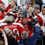 Northeastern forward Justin Hryckowian (29) holds the Beanpot trophy after defeating Boston University in overtime at TD Garden.