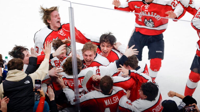 Northeastern players surround forward Gunnarwolfe Fontaine (11) after his game-winning goal in overtime to defeat Boston University in the Beanpot Tournament final at TD Garden.