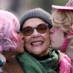 Actor Annette Bening, center, Hasty Pudding 2024 Woman of the Year, receives a kiss from Harvard University theatrical students Nikita Nair, left, and Joshua Hillers, right.