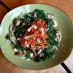 A meal from Life Alive cafe in a green bowl on a wooden table.