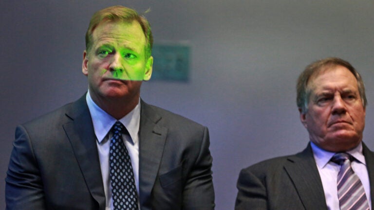 On the morning following their come from behind Super Bowel victory, New England Patriots quarterback Tom Brady and head coach Bill Belichick were present at a press conference along with NFL commissioner Roger Goodell. Brady accepted the Super Bowl MVP award from Goodell. Goodell (left) and Belichick (right) are pictured as they sit together off stage and listen to Brady at the microphone. The green on Goodell's face is from a video screen that was positioned just off stage.