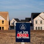 A sold sign in front of homes under construction.