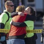A hug over police tape after shots were fired near the Kansas City Super Bowl victory parade in Kansas City, Mo., Feb. 14, 2024.