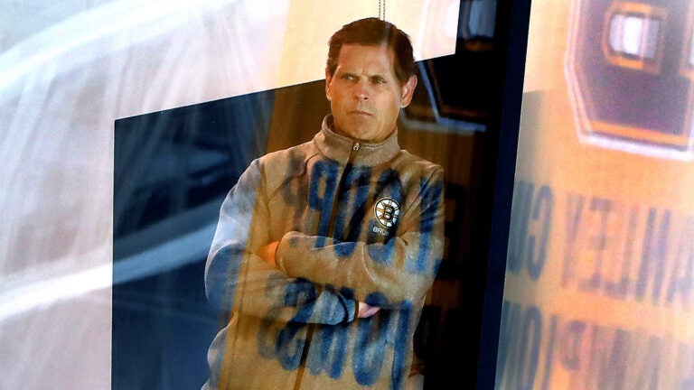 Bruins GM Don Sweeney leans on a beam as he watches the practice from his office. The Boston Bruins held their first day of practice their training camp at the Warrior Ice Arena.