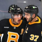 Boston 10/27/22 Boston Bruins vs Detroit Red Wings-Boston Bruins left wing Brad Marchand (63) (left) is congratulated by Boston Bruins center Patrice Bergeron (37) after Marchand’s 3rd period goal.