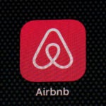 The Airbnb app icon is displayed on an iPad screen.
