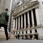 People pass the front of the New York Stock Exchange.