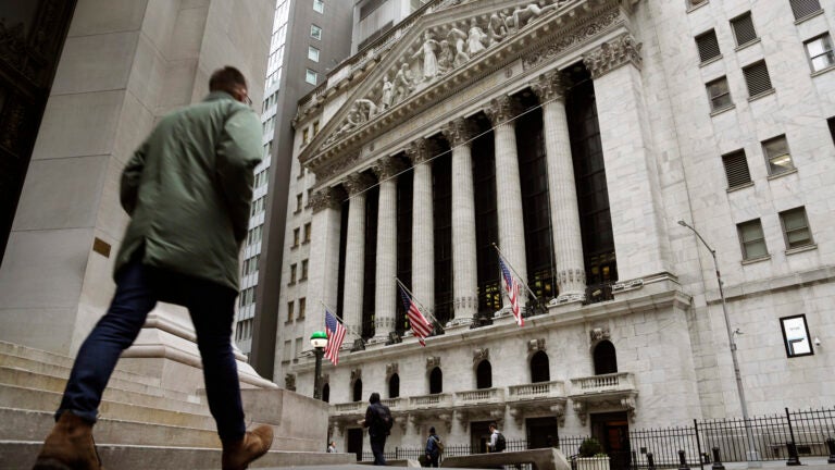 People pass the front of the New York Stock Exchange.