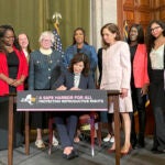 New York Gov. Kathy Hochul, center, signs bills expanding reproductive healthcare.