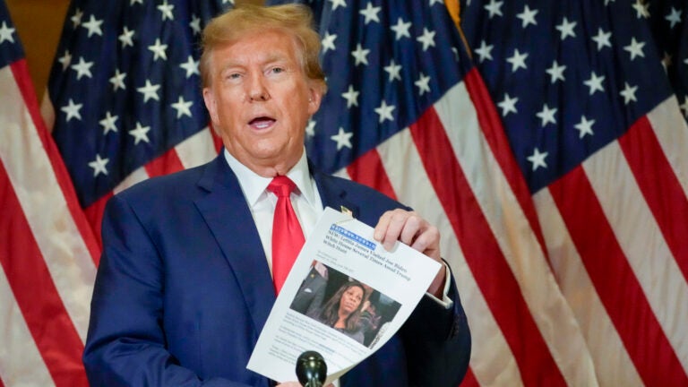 Former President Donald Trump holds up a copy of a story featuring New York Attorney General Letitia James.