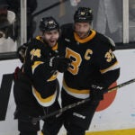 Boston Bruins Jake DeBrusk (L) celebrates his goal against the Ottawa Senators Goalie with teammate Patrice Bergeron during the first period of play at TD Garden.