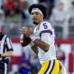 LSU quarterback Jayden Daniels (5) warms up during a timeout in the first half of an NCAA college football game against Alabama, Saturday, Nov. 4, 2023, in Tuscaloosa, Ala.