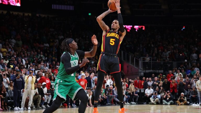 Dejounte Murray of the Atlanta Hawks hits the game-winning basket against Jrue Holiday of the Celtics during overtime.