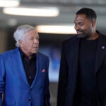 New England Patriots owner Robert Kraft, left, and newly-named Patriots head coach Jerod Mayo, right, walk together Wednesday, Jan. 17, 2024, as they arrive at an NFL football news conference, in Foxborough, Mass. Mayo succeeds Bill Belichick as the franchise's 15th head coach.