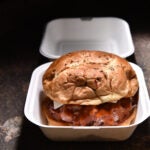 A roast beef sandwich in a take-out container.