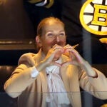 Singer Celine Dion makes a heart-shape with her hands after she was shown on the large tv screen as she watched the Bruins vs Rangers game from her seat in a 6th floor suite Thursday night. At TD Garden.