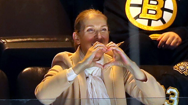 Singer Celine Dion makes a heart-shape with her hands after she was shown on the large tv screen as she watched the Bruins vs Rangers game from her seat in a 6th floor suite Thursday night. At TD Garden.