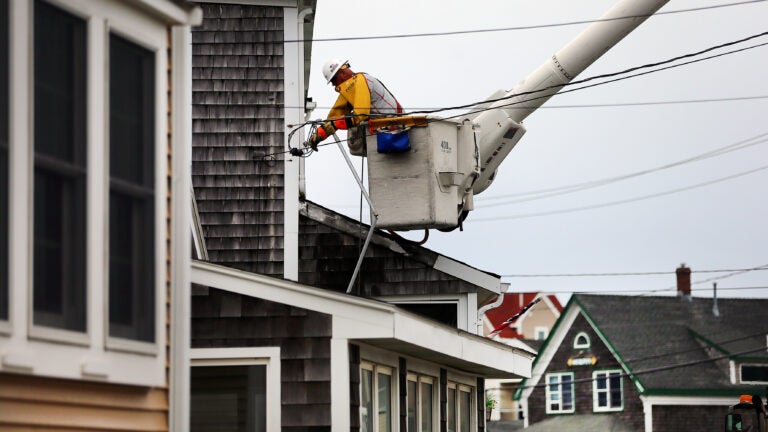 An Eversource worker repairs the electrical device to a home in Brant Rock.